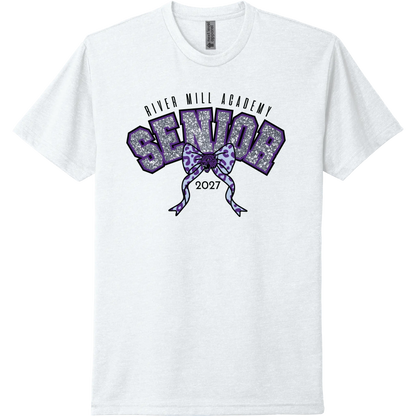 A white short-sleeve t-shirt with a purple and silver glittery graphic on the chest reading 'River Mill Academy Senior 2027' with a bow design.