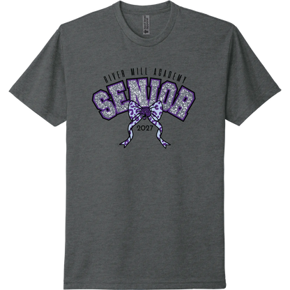 A charcoal gray short-sleeve t-shirt with a purple and glittery silver graphic on the chest reading 'River Mill Academy Senior 2027' with a bow design.